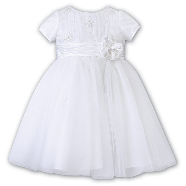 Sarah Louise Ceremonial Ballerina Dress in white, a delicate hand-pleated bodice with clusters of flowers adorned with pearls and a beautiful Satin flower at the waist.