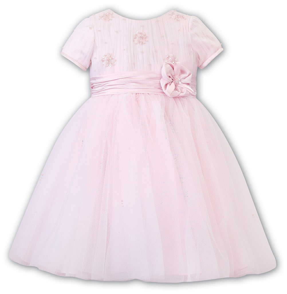 Sarah Louise Ceremonial Ballerina Dress in a delicate hand-pleated bodice with clusters of flowers adorned with pearls and a beautiful Satin flower at the waist. Sarah Louise Ceremonial Ballerina Dress in a delicate hand-pleated bodice with clusters of flowers adorned with pearls and a beautiful Satin flower at the waist.