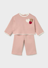 Mayoral A two-piece baby set in dusty pink, featuring a long-sleeve top with white ribbed trim and a teddy bear applique with hearts on the chest, paired with matching cropped pants.