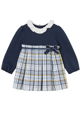 Mayoral toddler girl's long-sleeve dress with a solid navy blue bodice, a white ruffled collar, and a pleated plaid skirt in navy, white, and yellow. A matching navy bow is tied at the waist.