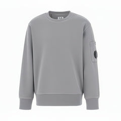 C.P. Company boys' diagonal fleece crewneck sweatshirt with iconic lens detail, ribbed texture, and reinforced cuffs and hem. Regular fit for everyday versatility. Smoke Grey