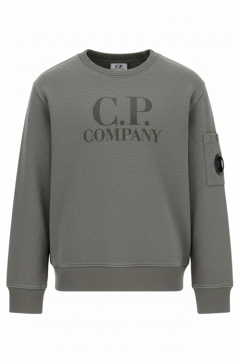 CP Company Kids sweatshirt with printed logo details and iconic lens detail, ribbed texture, and reinforced cuffs and hem. Regular fit for everyday versatility. Grey