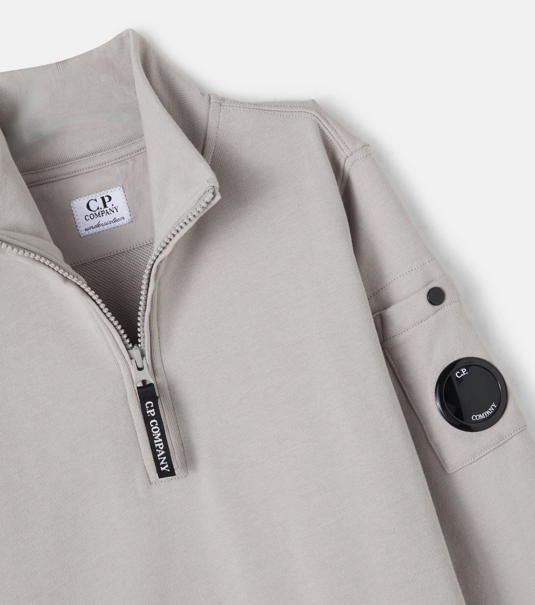 C.P. Company boys' U16 diagonal fleece half zip closure, high neck sweatshirt with iconic lens detail, ribbed texture, and reinforced cuffs and hem.