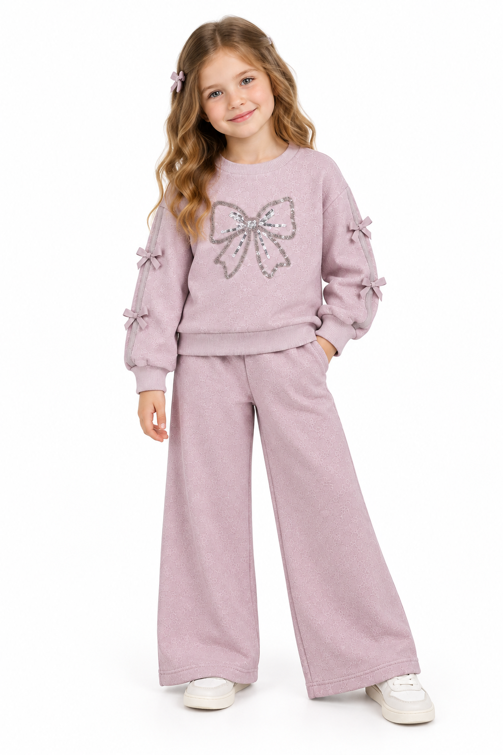 Giorgio Bambini girls light purple coloured tracksuit featuring a sequined bow detail on the front. Crafted from soft, stretchy cotton with fleece backing for warmth and comfort. Ribbed cuffs with decorative bows on the sleeves. Wide-leg bottoms complete the set.