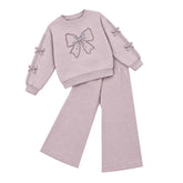 Giorgio Bambini girls light purple coloured tracksuit featuring a sequined bow detail on the front. Crafted from soft, stretchy cotton with fleece backing for warmth and comfort. Ribbed cuffs with decorative bows on the sleeves.
