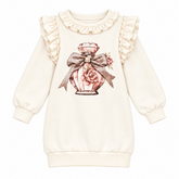A charming dress from Giorgio Bambini featuring a perfume bottle design embellished with diamante detailing. Delicate pearl and ruffles add elegance.