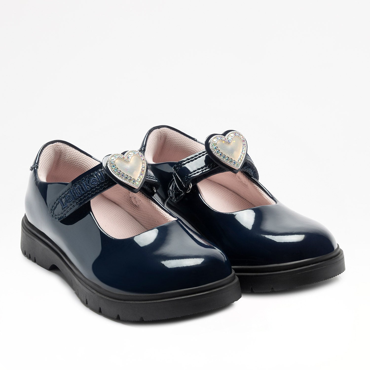 Lelli Kelly Sabrina comes in a navy patent upper. Sabrina has a hook and loop fastening. A large enamel heart with a diamate framed charm, sits on the strap fastening which changes colour in the sunlight. The charm can be slid off and replaced with a large bow. Pink textile lining and chunky sole unit completes the look.