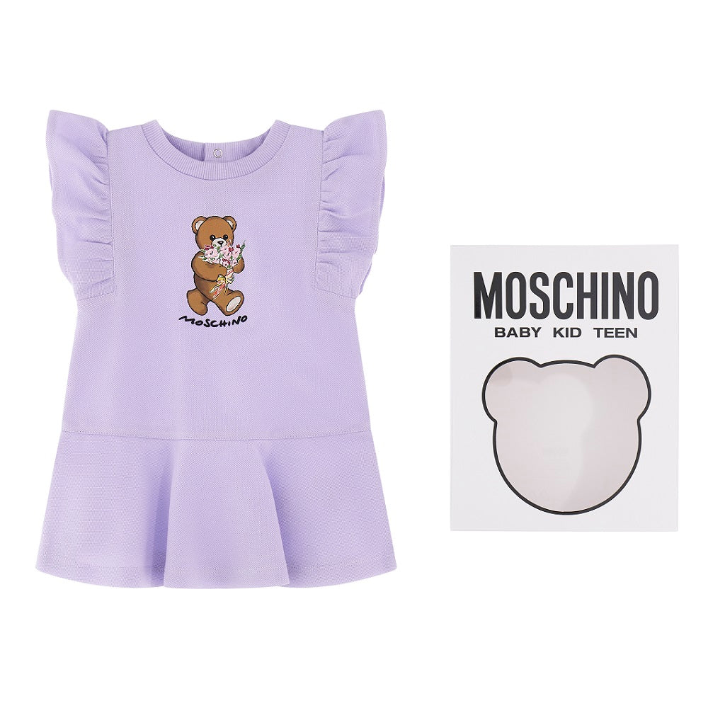 A MOSCHINO baby girls dress in pastel lilac cotton piqué, adorned with the brand's signature teddy bear print and rubberized logo
