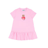 MOSCHINO Baby Girls dress featuring the iconic Teddy Bear clutching a heart. Crafted from soft cotton jersey with short sleeves, dropped waist, and gathered skirt.