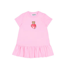 MOSCHINO Baby Girls dress featuring the iconic Teddy Bear clutching a heart. Crafted from soft cotton jersey with short sleeves, dropped waist, and gathered skirt.
