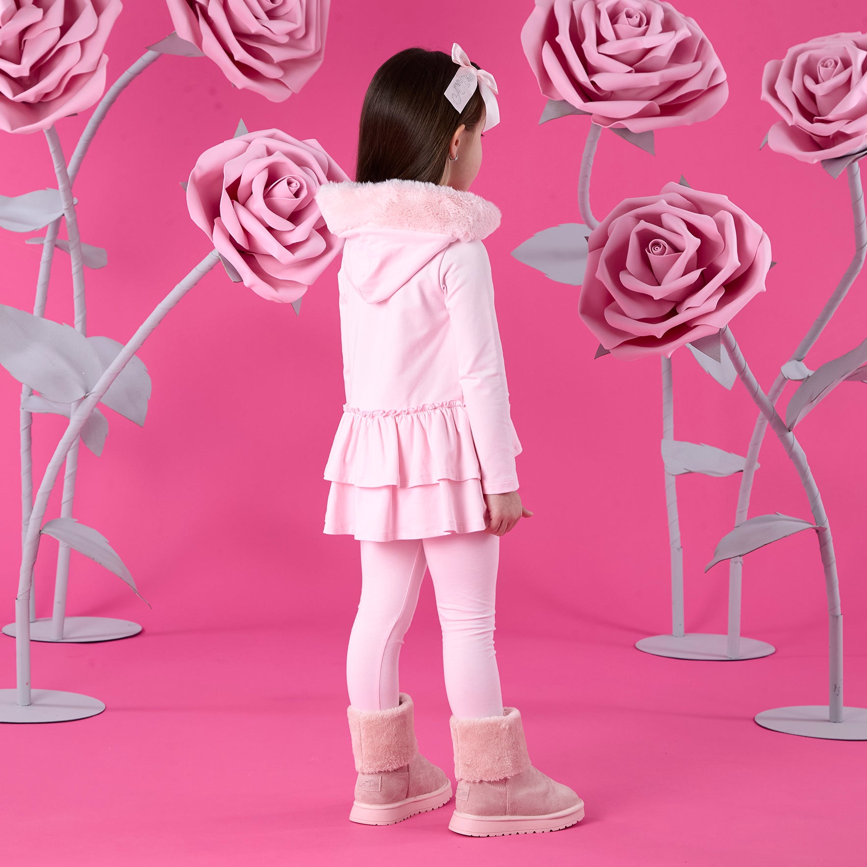 ADEE Winter Bloom Collection. The Alina Legging Set is the perfect addition to your Winter wardrobe! Featuring a fur trimmed hooded top with applique bows and frilled hems. Paired with matching leggings with applique bows at the ankle. Pale Pink