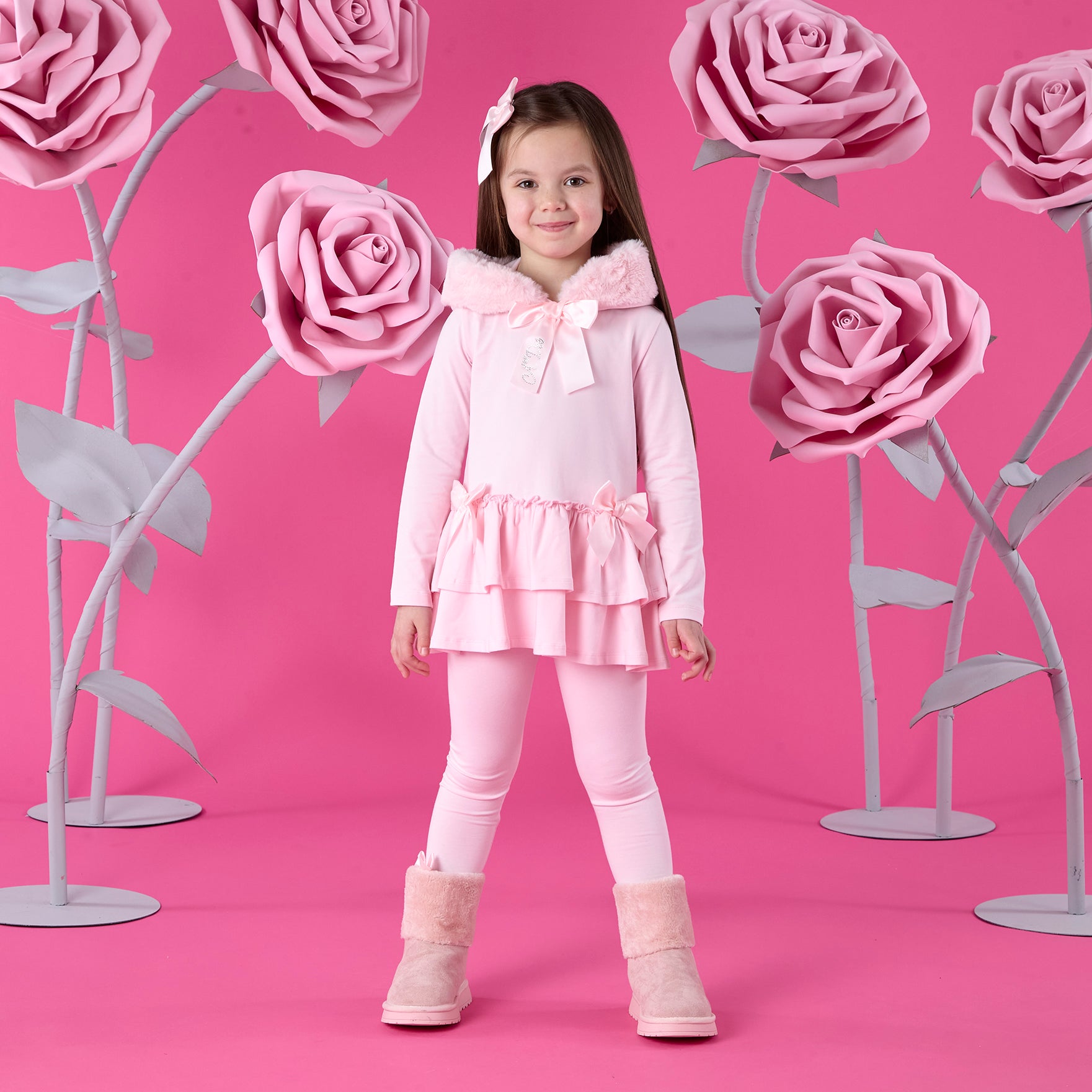 ADEE Winter Bloom Collection. The Alina Legging Set is the perfect addition to your Winter wardrobe! Featuring a fur trimmed hooded top with applique bows and frilled hems. Paired with matching leggings with applique bows at the ankle. Pale Pink