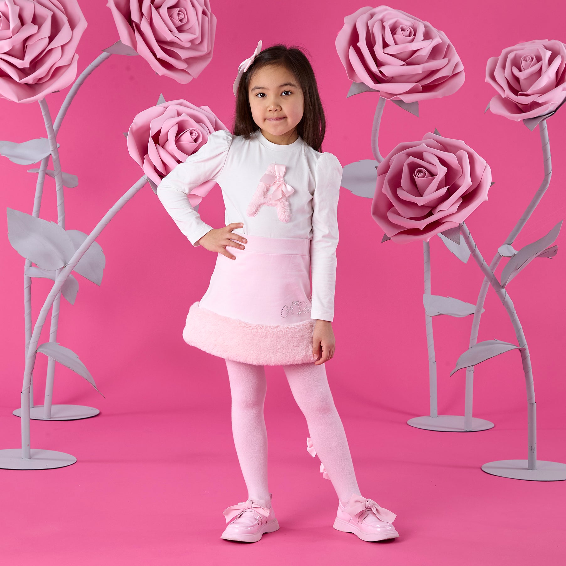 ADEE Winter Bloom Collection. The Andrea Set features a long-sleeved top with gorgeous faux fur “A” artwork on the front, paired perfectly with a pink skirt finished with soft faux fur trim. This is a winter wardrobe must have!