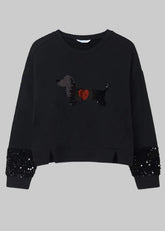 Mayoral girls black crewneck sweatshirt featuring a sequined dachshund dog graphic with a red heart on the chest, and black sequined cuffs on the sleeves.