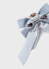 Mayoral light blue-gray velvet ribbon hair bow embellished with two fabric flowers, one in dusty blue-gray and one in soft pink.