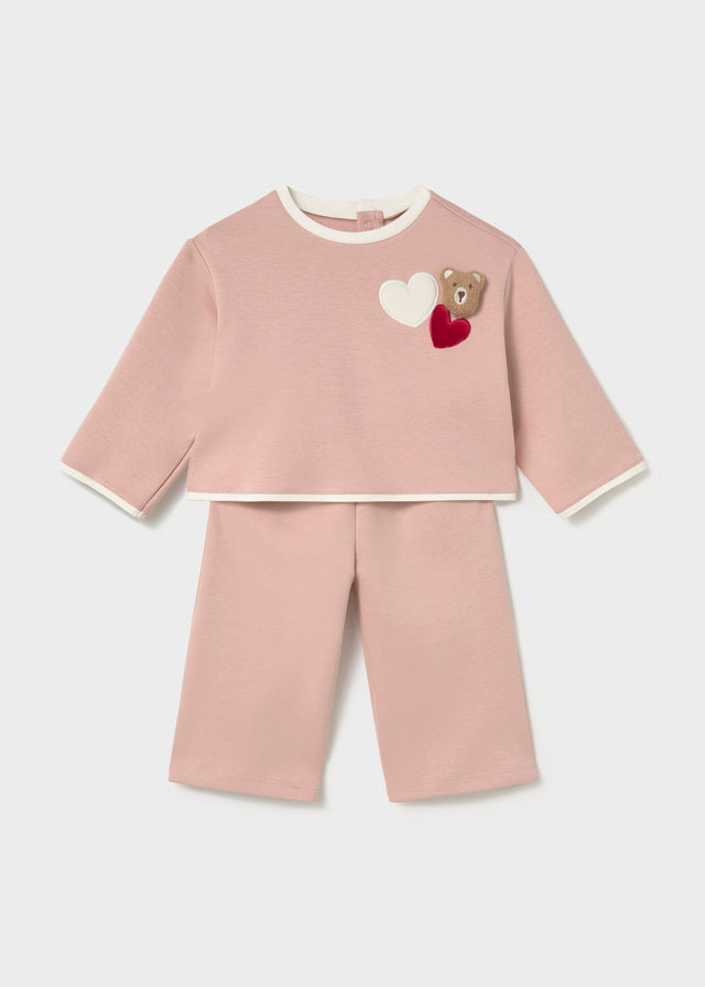 Mayoral A two-piece baby set in dusty pink, featuring a long-sleeve top with white ribbed trim and a teddy bear applique with hearts on the chest, paired with matching cropped pants.