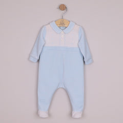EMILE et ROSE Monty Sumptuous white and blue velour is the fabric of choice for this lovely cosy babygrow. The top of the garment is white with beautifully embroidered, alternate vertical columns of spots, diamonds and crosses. Below the soft blue collar are three pearlised buttons, the rest of the garment is pale blue with contrasting white feet.