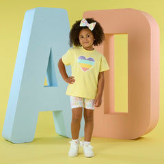 ADEE Signature Summer The Saz cycling short set features an oversized t-shirt with a sequined heart artwork on the front. Paired with initial print cycling shorts