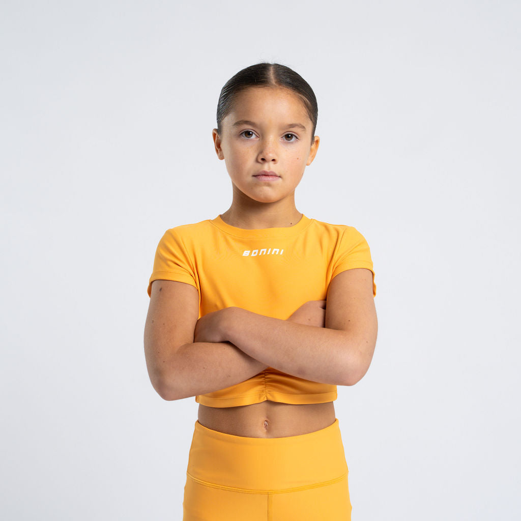 BONINI by ADee The Aspire short sleeve ruched t-shirt. Made from our signature fabric, a blend of polyester and elastane for ultimate stretch and comfort, it features ruched detail on the front and is finished with Bonini branding on the front. Florida Orange