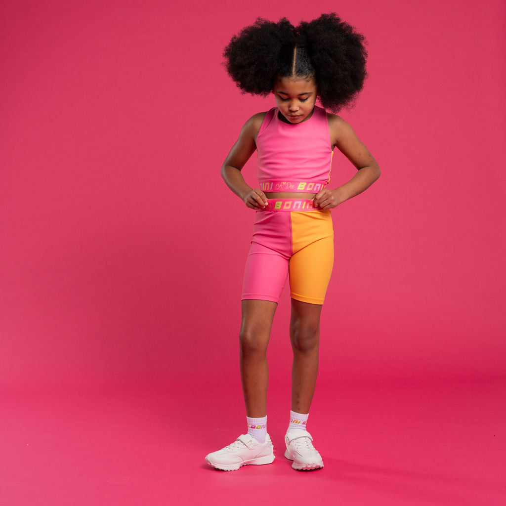 BONINI by ADee The Flex colour block crop top features logo tape cross back straps and is designed to match pieces within the collection. Hot Pink