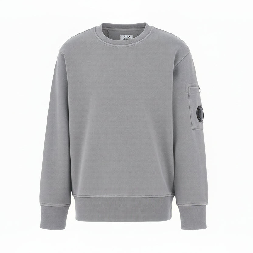 C.P. Company boys' diagonal fleece crewneck sweatshirt with iconic lens detail, ribbed texture, and reinforced cuffs and hem. Regular fit for everyday versatility. Smoke Grey