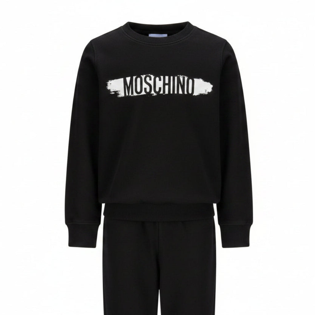 Moschino Kids Tracksuit in black, featuring logo print in white and black on the front of sweatshirt and also on the jogger trousers. Elasticated waistband and ribbed trims for comfort. Suitable for boys and girls.