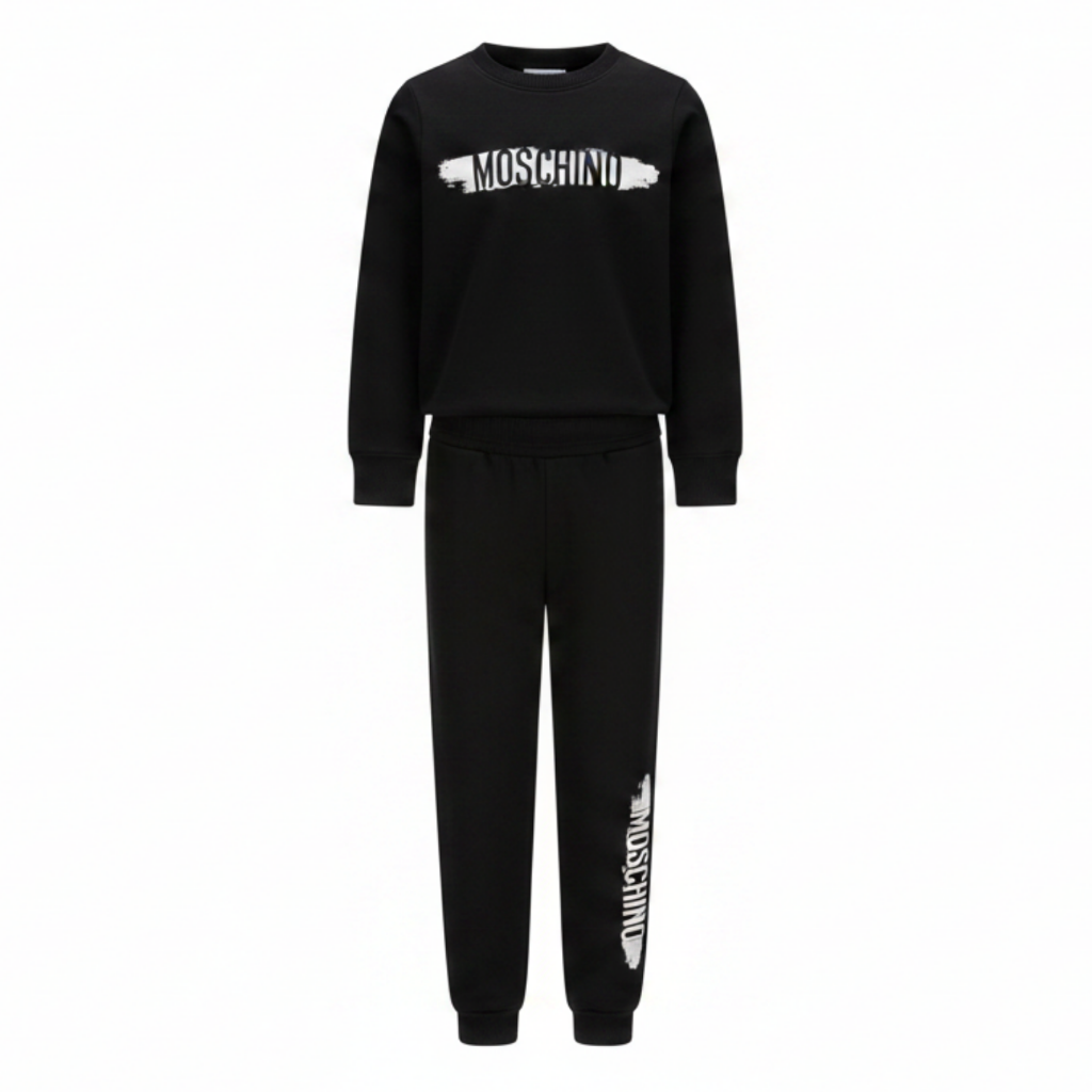 Moschino Kids Tracksuit in black, featuring logo print in white and black on the front of sweatshirt and also on the jogger trousers. Elasticated waistband and ribbed trims for comfort. Suitable for boys and girls.