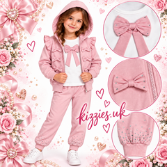 Georgio Bambini girls pink three-piece tracksuit with ruffle details, bow embellishments, and rhinestone accents. The set includes a hooded zip-up jacket and matching jogger pants.
