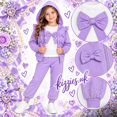 Girls lavender purple three-piece tracksuit with top, matching hooded jacket and joggers, featuring decorative bows, ruffle details, and rhinestone embellishments. Kizzies