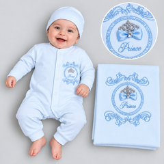 Baby boys wearing a light blue long-sleeve romper and matching beanie with matching blanket. The sleeper and blanket have a blue ornate crest with a crown, bow, and the word 'Prince'.