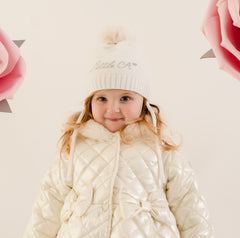 Little A by ADee Little Bloom Collection. The Diamond hat features a knitted design with a soft ribbed finish and a fluffy pom pom on top. Finished with tie fastenings for a snug and secure fit. Snow White