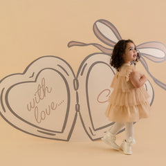 LITTLE A by ADee Little Locket theme. The Ella dress features layered tulle frills and flutter sleeves. Finished with a tiered skirt for a beautifully floaty, dressy look. Stone Beige