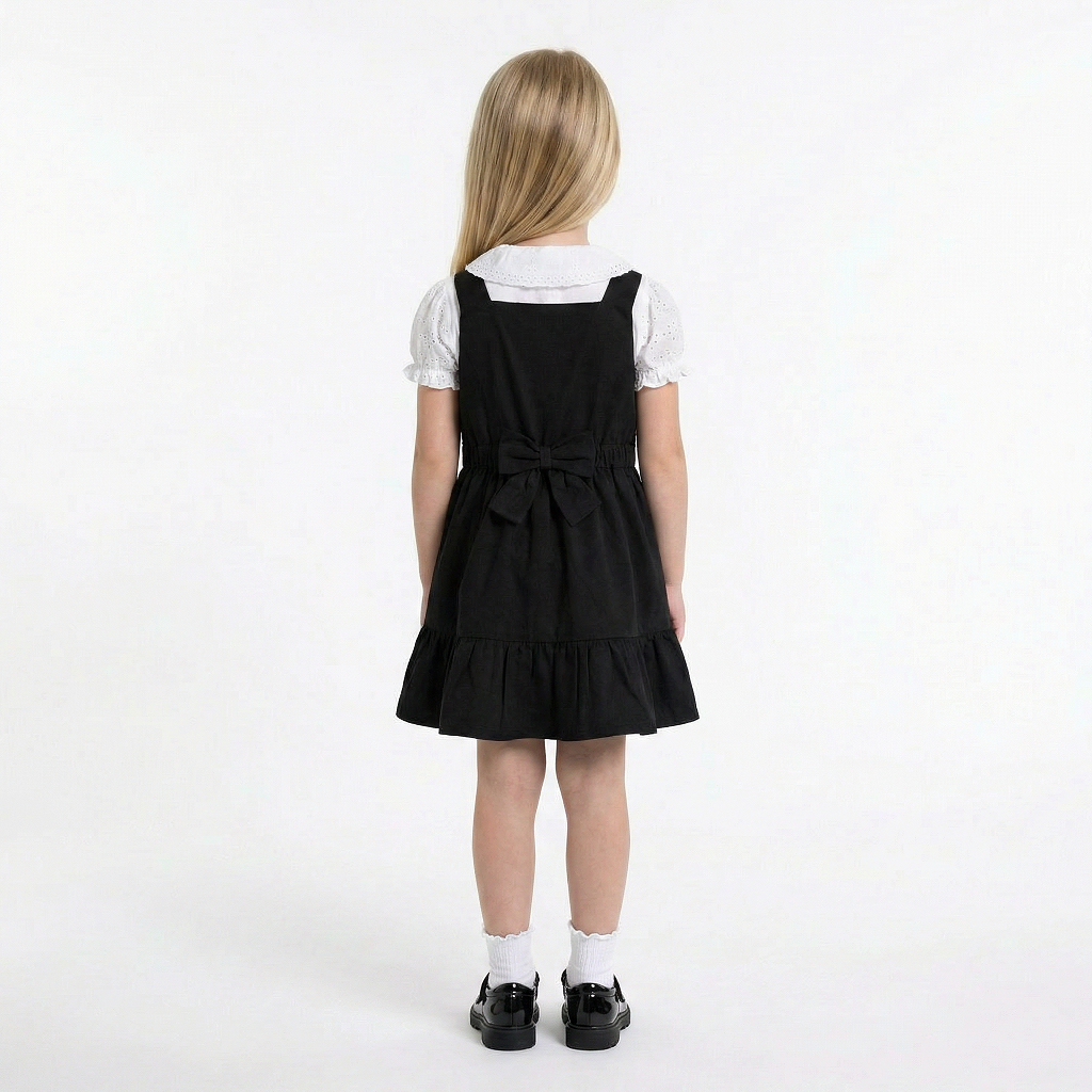 LELLI KELLY Becky Black School Pinafore featuring a charming bow detail on the back and charm with LELLI KELLY logo on the front