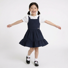 LELLI KELLY Becky Navy School Pinafore featuring a charming bow detail on the back and charm with LELLI KELLY logo on the front