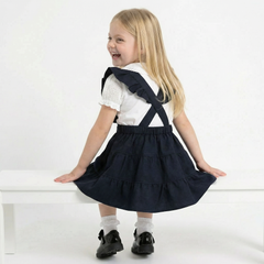 LELLI KELLY Bryony Navy Frill Pinafore featuring cross over strap detail on the back and charm with LELLI KELLY logo on the front