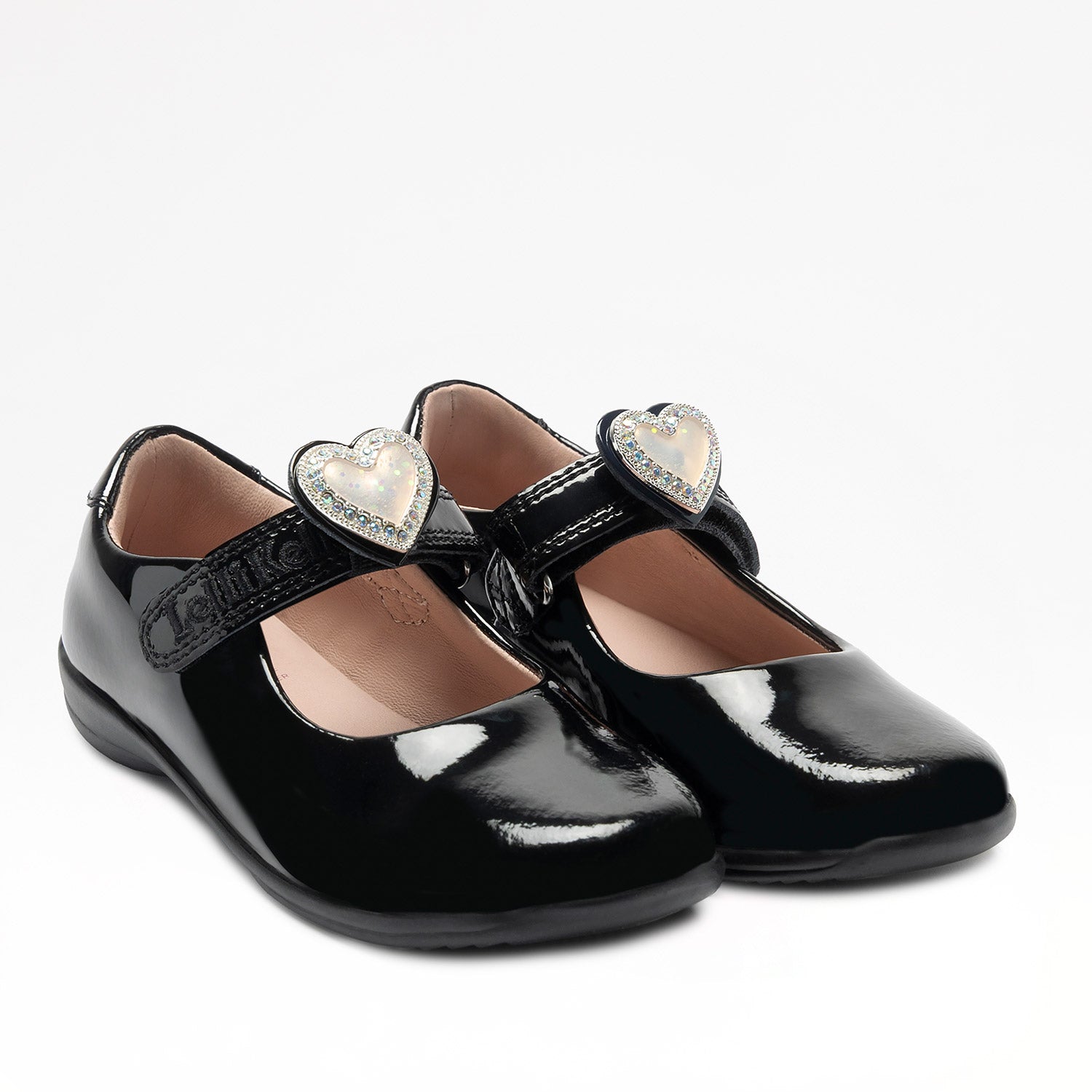 Lelli Kelly Sabrina comes in a black patent upper. Sabrina has a hook and loop fastening. A large cream diamante framed heart that changes colour in the sunlight sits on the strap fastening and this can be slid off and replaced with a bow. Pink Leather lining completes the look