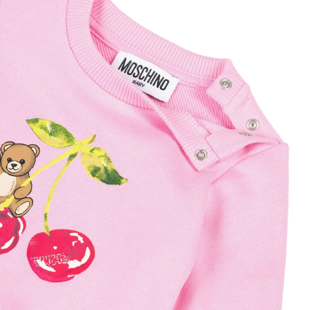 Pink cotton jersey sweatshirt by Moschino for baby girls, featuring a teddy bear and cherry motif with ribbed trims and shoulder poppers.