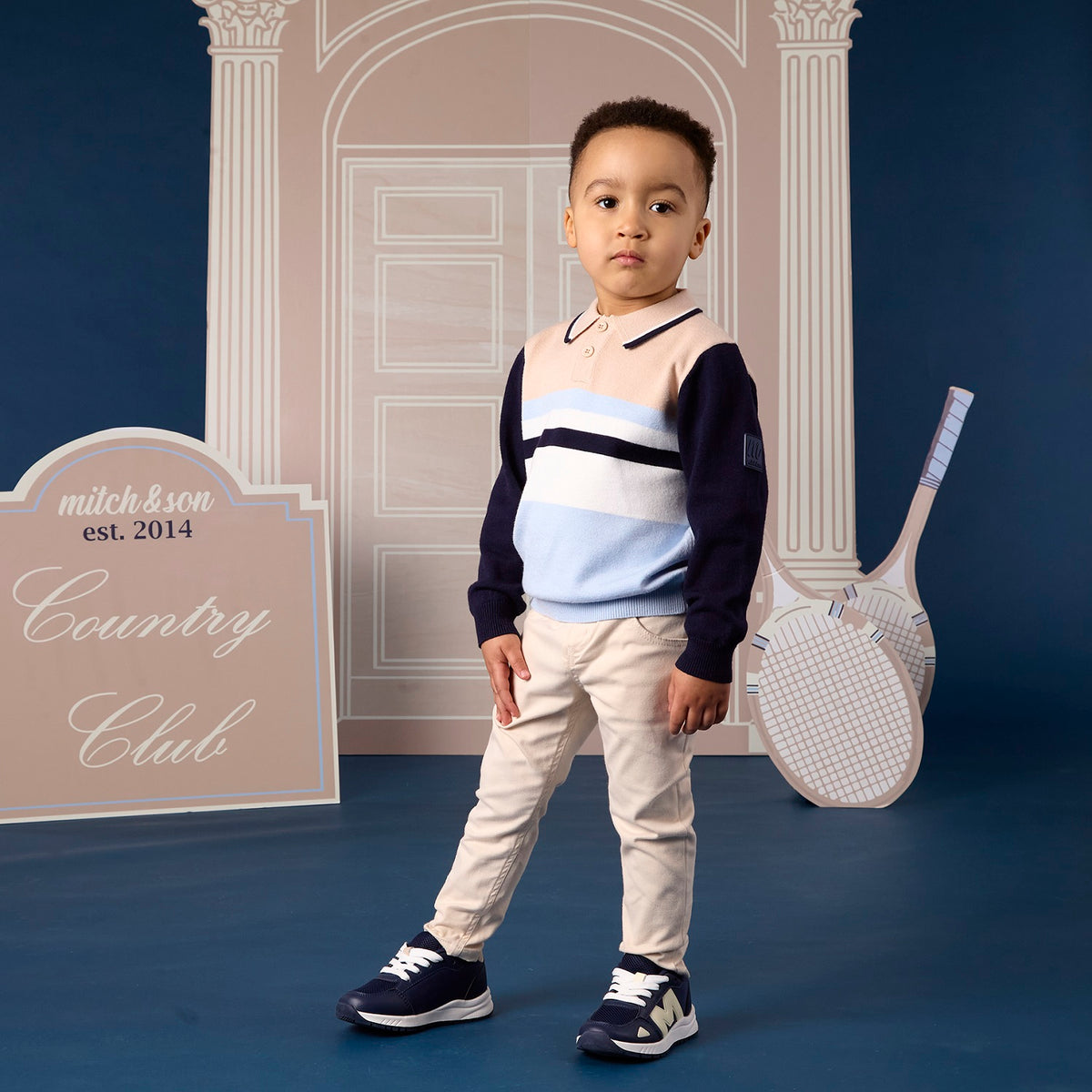 MITCH & SON Classic Collection. The Sebastian knitted polo features a colour block stripe design with a classic collar and button placket. Finished with ribbed trims and a signature chest badge. Paired with Silas trousers feature a classic woven design with a button fastening and elasticated side tabs for a comfortable fit. Finished with side and back pockets and subtle logo detailing. Stone Beige