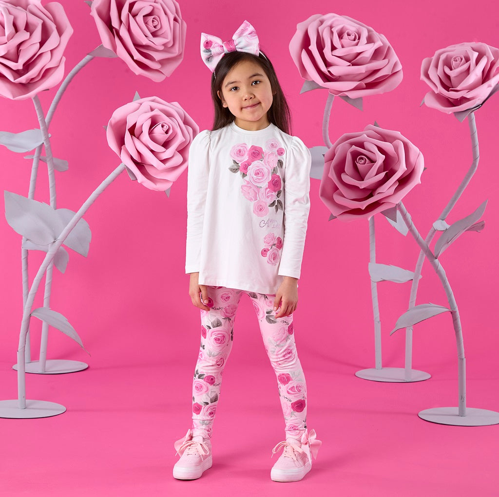 ADEE Winter Bloom Collection. The Ayla Set features a white tunic top with beautiful rose artwork on the front and a contrast printed back insert with bow detail. Paired with matching rose-print leggings to complete the look.