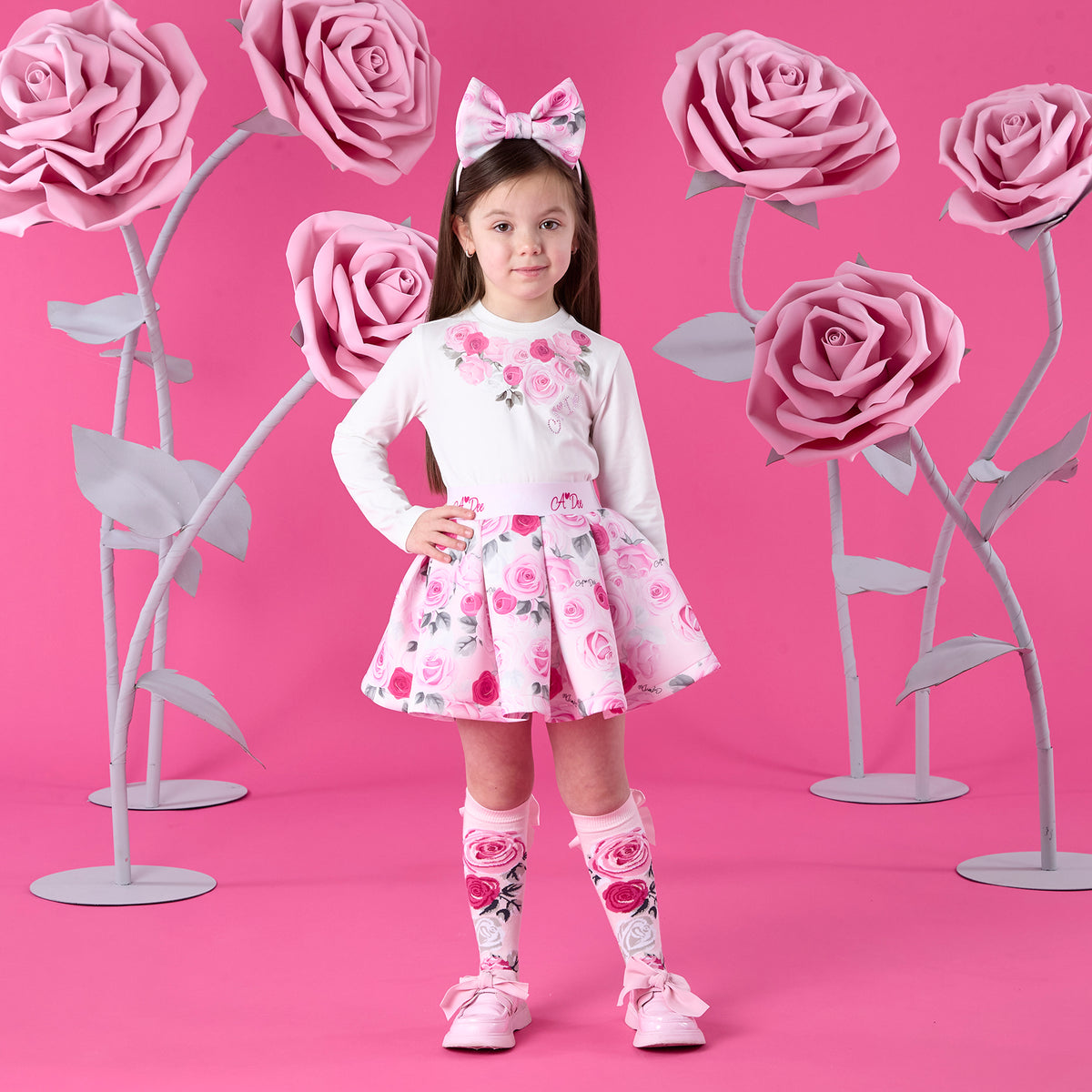ADEE Winter Bloom Collection. The Ariella Set includes a long-sleeved top featuring beautiful roses artwork on the front, paired with a matching pleated rose-print skirt finished with a branded waistband