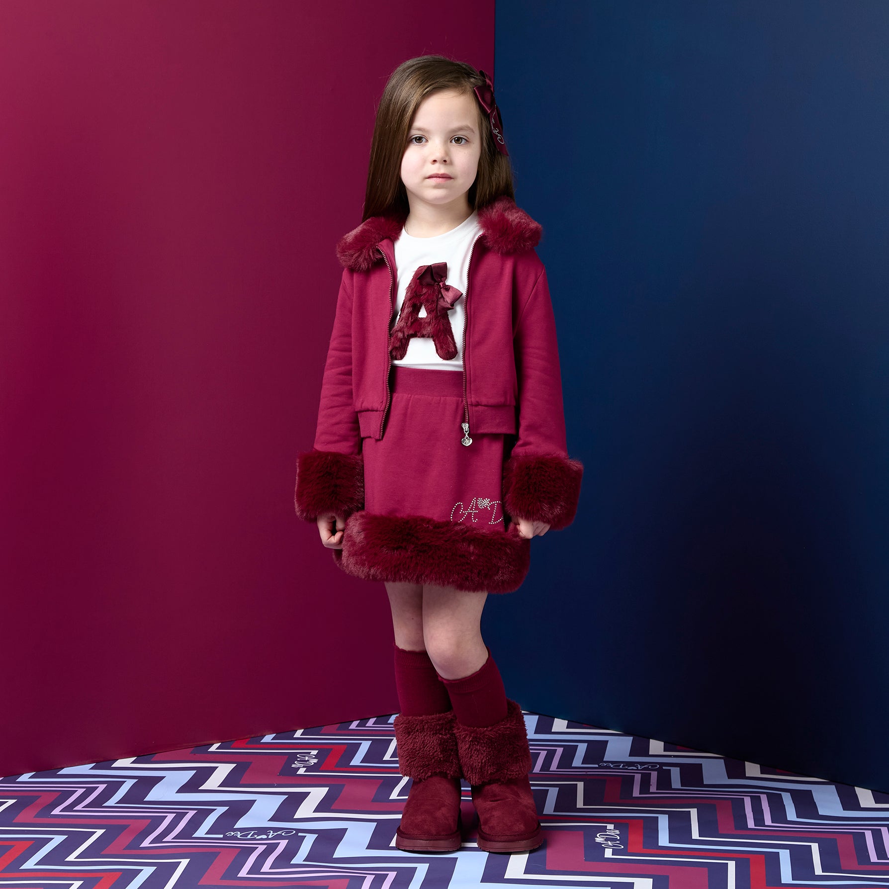 ADEE Chevron Charm theme. The Audrey Bomber features gorgeous fur trim detailing and a classic diamanté A*Dee logo across the back. Deep Cherry