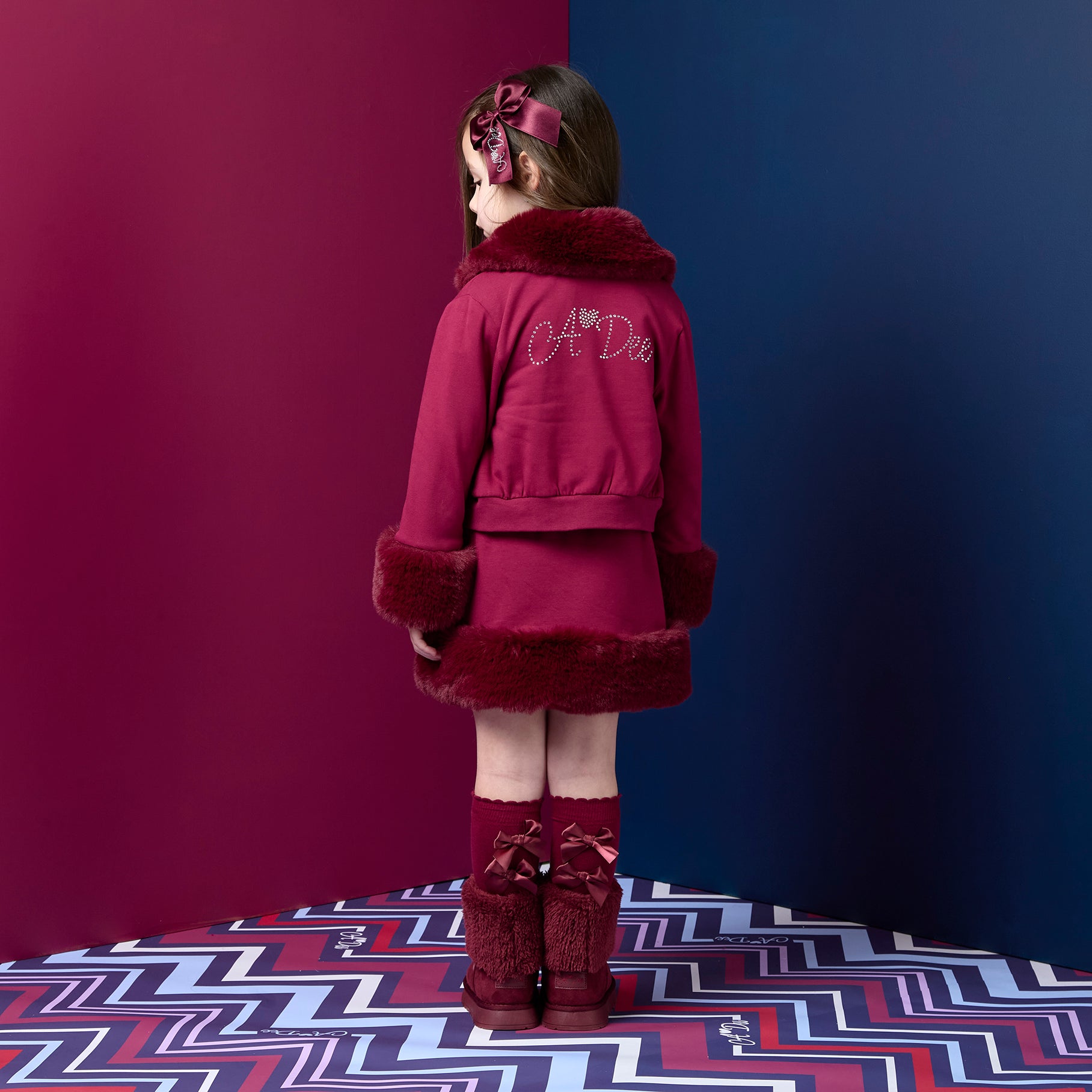 ADEE Chevron Charm theme. The Audrey Bomber features gorgeous fur trim detailing and a classic diamanté A*Dee logo across the back. Deep Cherry