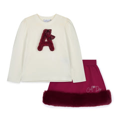 ADEE Chevron Charm Collection. The Andrea Set features a long-sleeved top with gorgeous faux fur “A” artwork on the front, paired perfectly with a red skirt finished with soft faux fur trim. This is a winter wardrobe must have! Snow White/deep Cherry