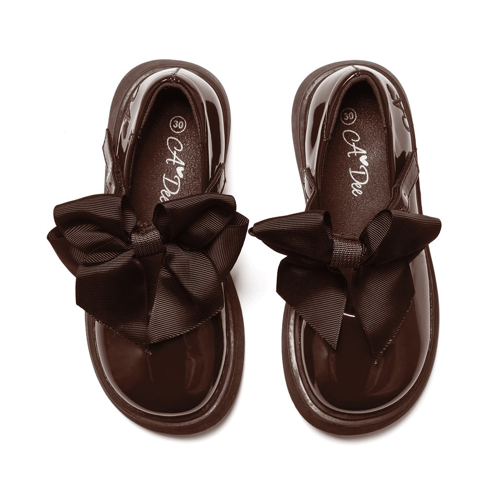 ADEE The Lyra shoe is perfect for school, with pretty bows on the velcro strap and embroidered logo to the side. Finished with non-slip rubber soles. Brown.