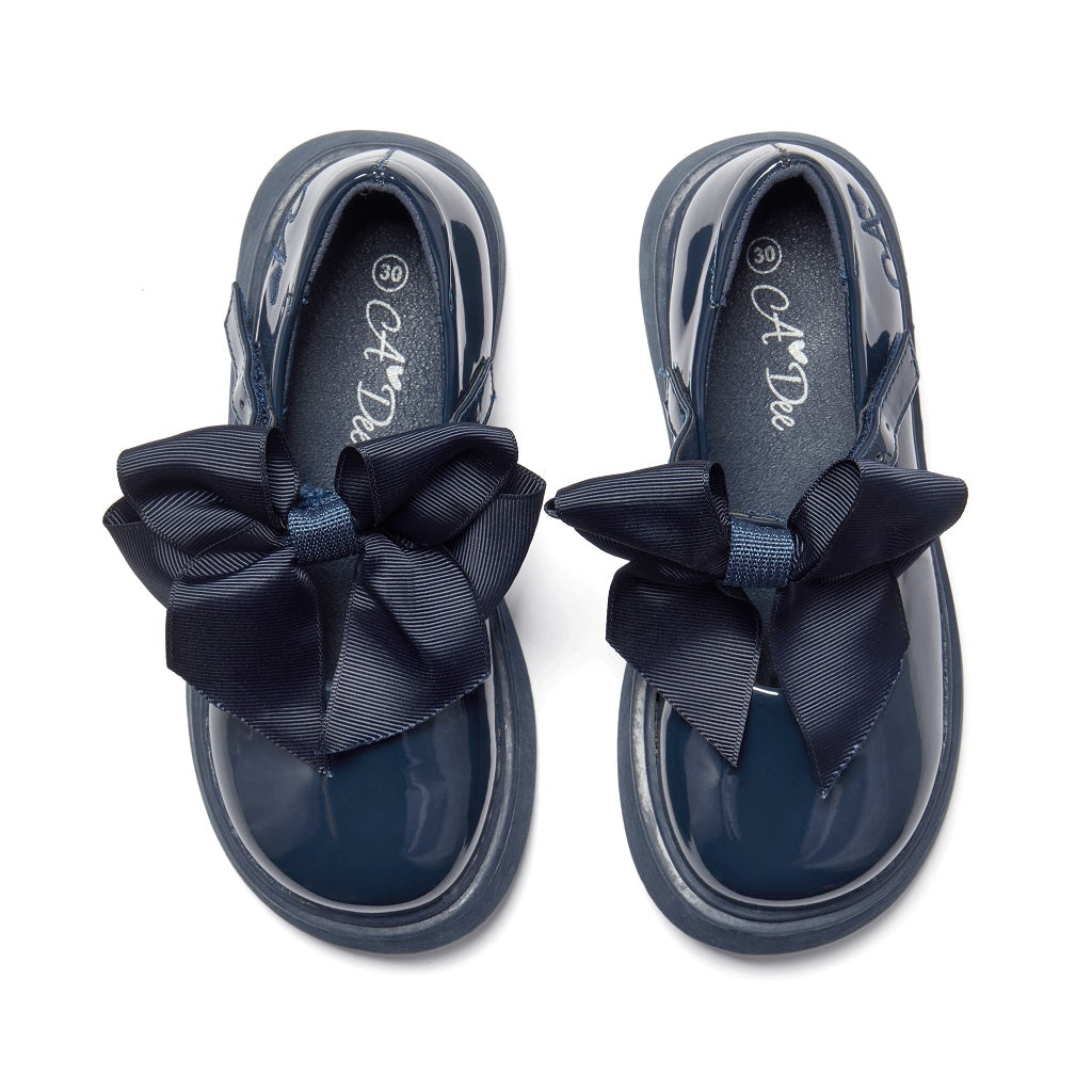 ADEE The Lyra shoe is perfect for school, with pretty bows on the velcro strap and embroidered logo to the side. Finished with non-slip rubber soles. Navy
