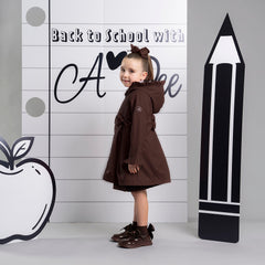 ADEE BTS The Nova is the must-have back to school raincoat! It features front and back pleats with pretty bow detailing, branding around the hem and frills at the cuffs and hood. Complete with a silver reflective logo badge on one arm and a silver branded puller. Brown