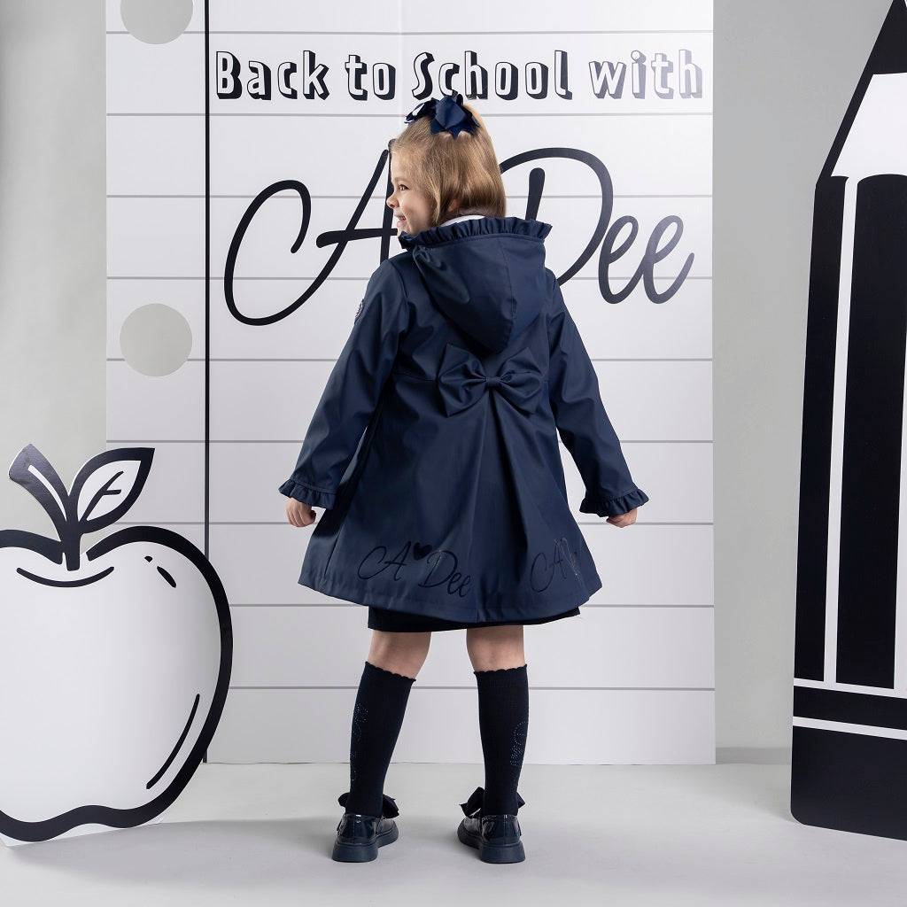ADEE BTS The Nova is the must-have back to school raincoat! It features front and back pleats with pretty bow detailing, branding around the hem and frills at the cuffs and hood. Complete with a silver reflective logo badge on one arm and a silver branded puller. Dark Navy