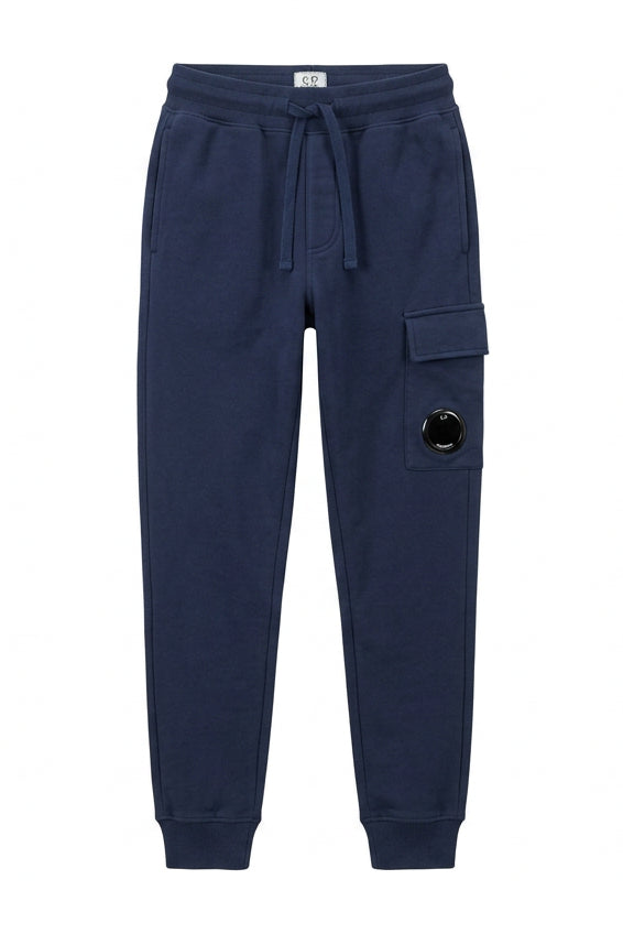 C.P. Company Kids track pants with signature lens details,  side cargo pocket, elasticated waistband and ribbed cuffs . 100% Cotton. Dusty Blue